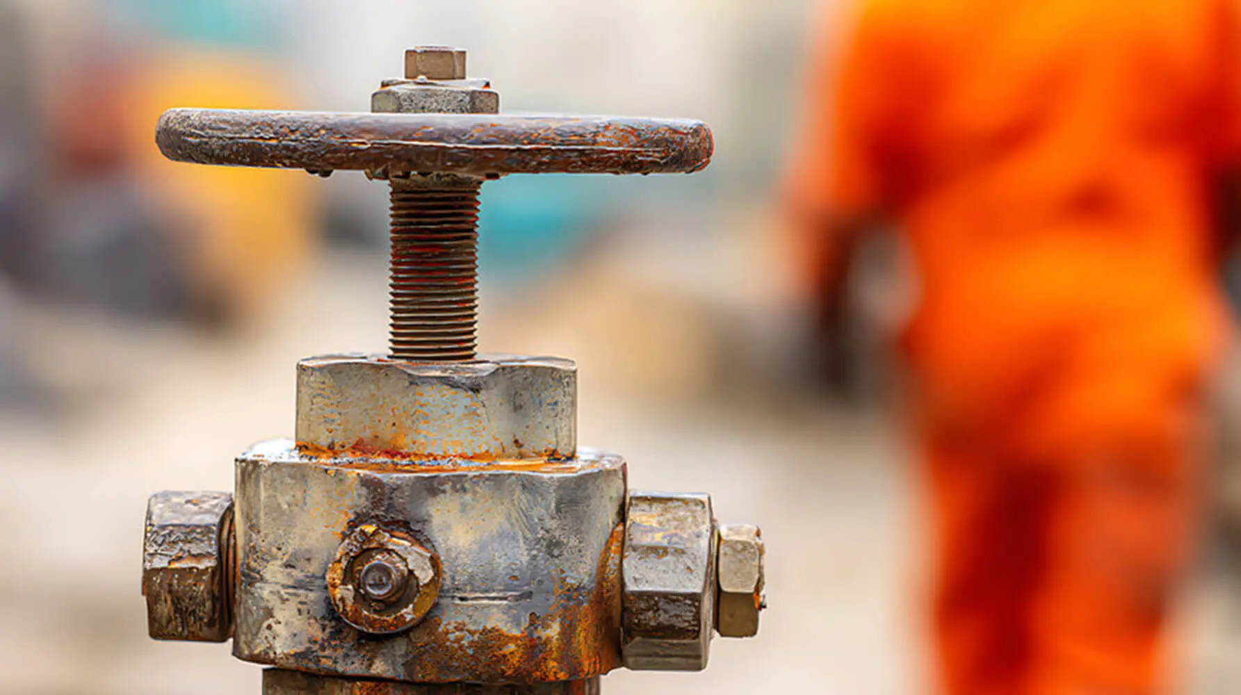 Close-up of a corroded industrial valve showing rust and coating failure, illustrating the signs industrial machinery needs repainting.